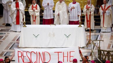 People hold a banner as Pope Francis presides over a mass at the Shrine of Sainte-Anne-de-Beaupre, one of the oldest and most popular pilgrimage sites in North America, in Sainte-Anne-de-Beaupre, Quebec, Canada July 28, 2022. The banner reads: "Rescind the doctrine".